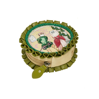 Round embroidered pouch with green ruffles on a white background