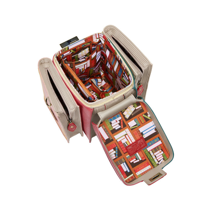 Open beige travel organizer with colorful book pattern on a white background