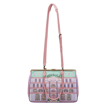 Handbag with architectural design and pink strap on a white background