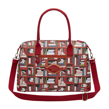 Handbag with book pattern and red handles and strap on a white background