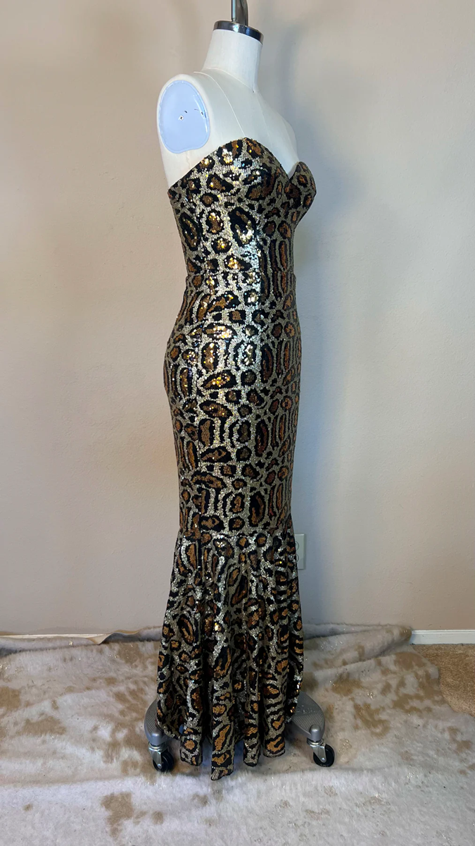 Leopard print evening gown on a mannequin against a plain background