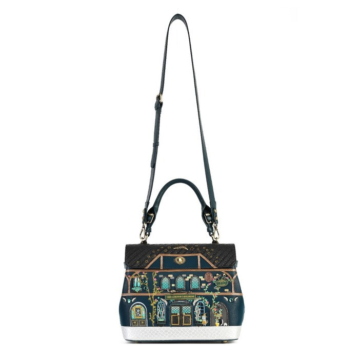 A structured handbag with a dark navy blue base, featuring an ornate, colorful architectural illustration on the front resembling a classic building facade. The bag has a black top handle, a long black shoulder strap, and gold-tone hardware.