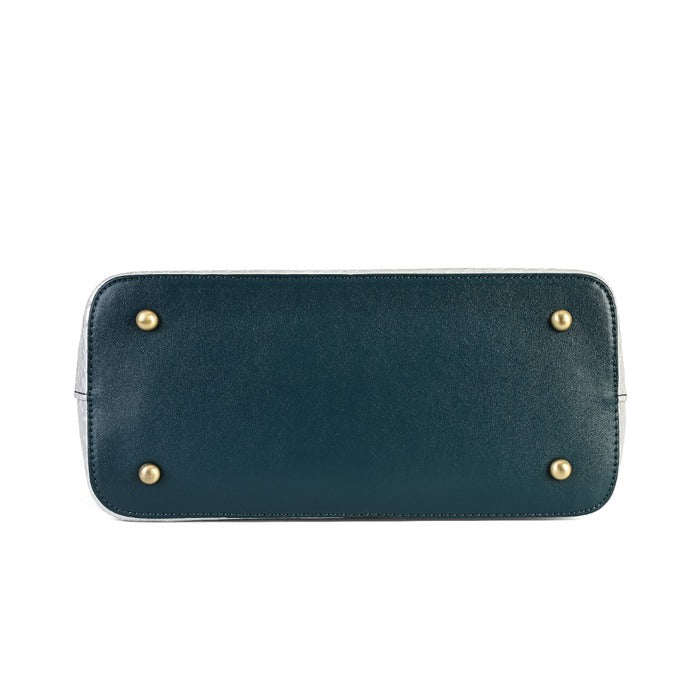 The bottom flap of a dark teal leather handbag, featuring four gold-tone metal studs, shown against a plain white background.