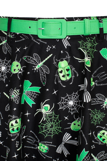 Black skirt with green and white insect pattern, worn with a green belt.