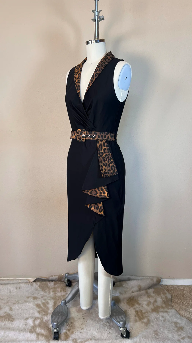 Black dress with leopard print accents on a mannequin against a beige wall.