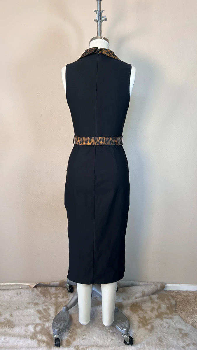 Black dress with a leopard print belt on a mannequin against a beige wall.