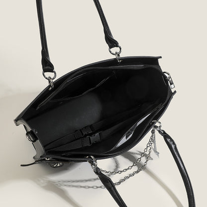 Black handbag with chain detail on a light background