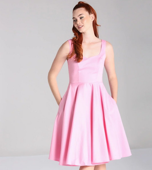 Woman wearing a pink dress against a gray background