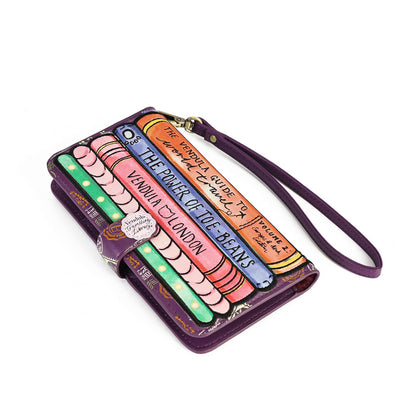 A purple leather wristlet wallet featuring a colorful, illustrated book cover design with text such as 'The Power of 106-Beams' and 'Venice to London,' plus a matching purple wrist strap on a white background.