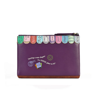 A purple zippered clutch bag with a row of colorful bookmark-like tabs along the top edge and white decorative text on the front, photographed on a clean white background.