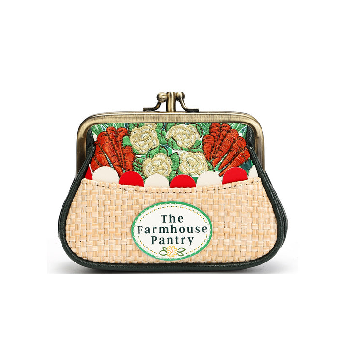 A small kiss-lock purse with a woven straw-like front and a printed vegetable-themed design on the back. The front has a round patch reading 'The Farmhouse Pantry.