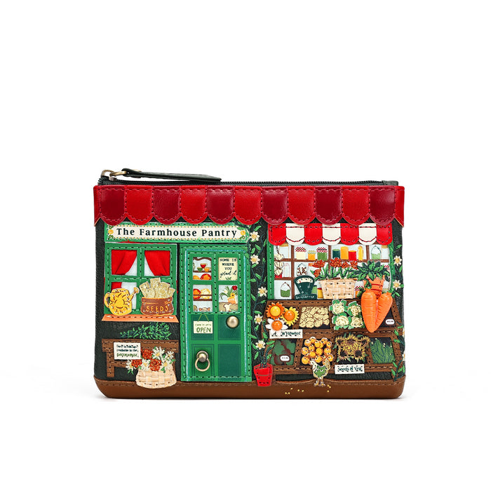 A small zip pouch designed to look like a detailed storefront illustration labeled 'The Farmhouse Pantry,' with red awnings, a green door, and illustrated produce and shop details, shown on a plain white background.