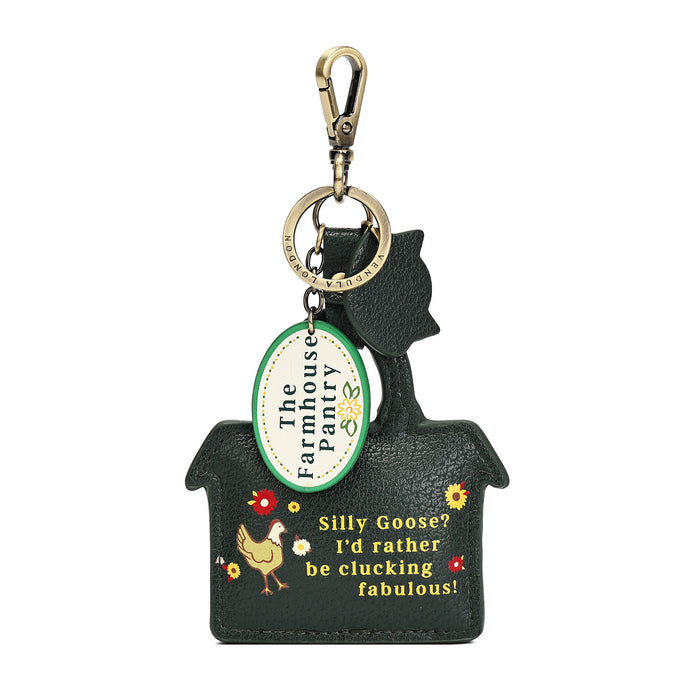 A Gucci handbag-shaped keychain or bag charm with a green leather handle, gold-tone clasp, and a detailed multicolor embroidered and embellished front panel featuring a market scene with fruits, vegetables, flowers, and a cat.