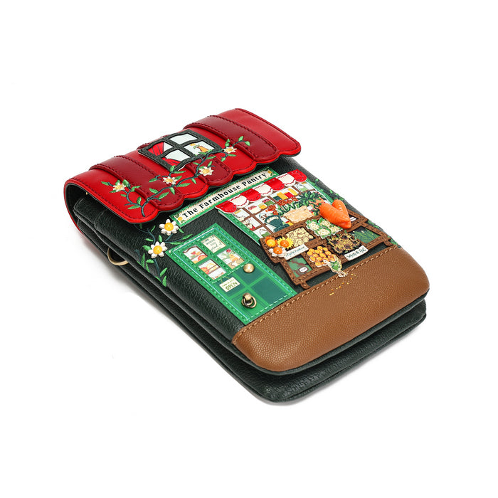 A decorative wallet with a red flap featuring floral embroidery and a central patch reading 'THE FASHIONABLE PANTS', set against a green background with a detailed market scene patch, and finished with a brown leather trim on a white background.