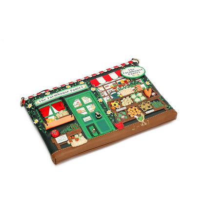 A whimsical, multi-textured clutch purse designed to look like 'The Farmhouse Parley' from The Little Mermaid. The clutch features a brown faux-leather base with a highly detailed, multi-textured top panel depicting a green house, red-and-white striped awning, flowers, and gardening elements.