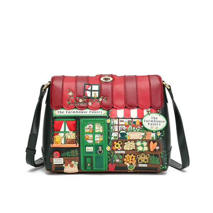 A black leather shoulder bag with a highly detailed, colorful patchwork design depicting 'The Farmhouse Pantry' storefront, featuring a red roof, green door, and various vegetable and flower illustrations, shown on a plain white background.