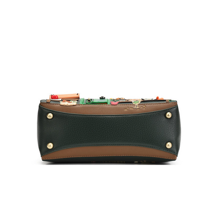 A structured leather clutch bag shown from the back, featuring a dark forest green pebbled leather body, a brown leather trim, gold-tone metal studs, and a colorful array of small pins and charms attached to the back panel.