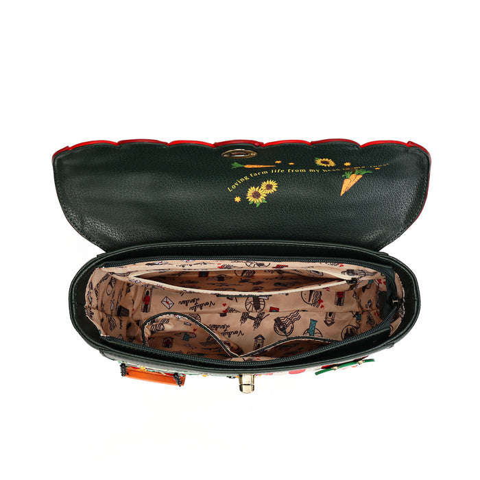 An open black pebbled leather clutch bag with a red trim, showing a patterned beige interior lining with vintage illustrations and a gold-tone clasp.
