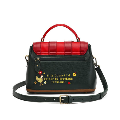 A black pebbled leather handbag with a bright red top handle and matching red quilted flap detail. The front features a black leather strap with gold-tone hardware and a humorous embroidered text design reading 'Silly Goose? I'd rather be stocking fabulous!' alongside a small chicken graphic.