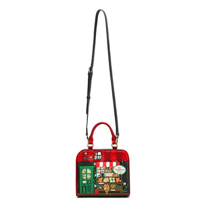 A red structured handbag with a black shoulder strap, featuring a colorful illustrated market stall design on the front panel.