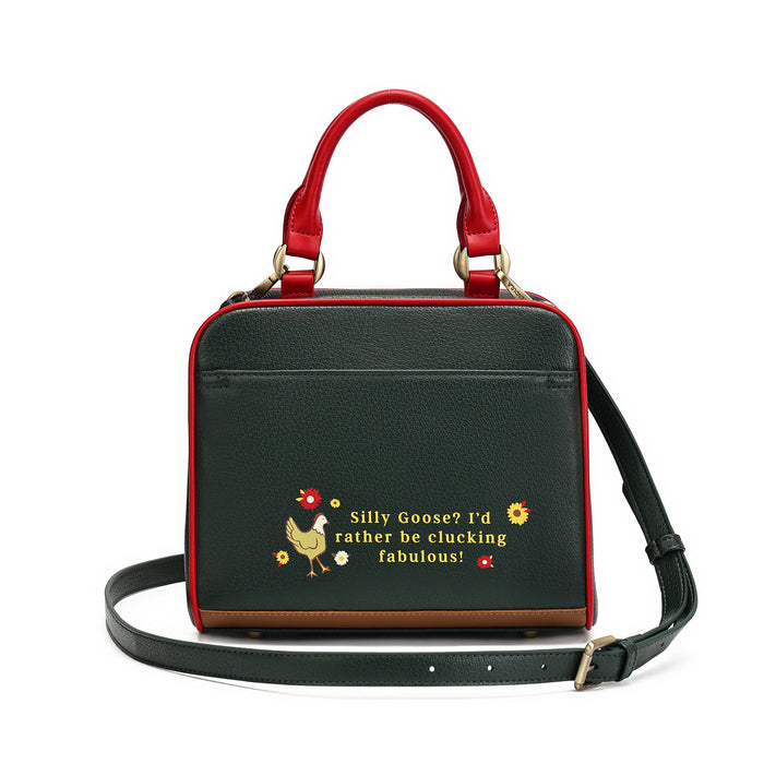 A structured black pebbled leather handbag with red leather handles and trim, featuring a brown leather base trim and a black shoulder strap. The front has a yellow embroidered chicken and the text 'Silly Goose? I'd rather be clucking fabulous!'.