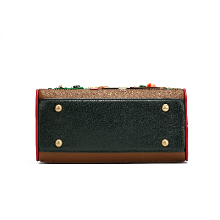 A rectangular leather clutch or wallet shown from the back, featuring a dark green pebbled leather back panel with four gold-tone rivets, a tan leather top and bottom, a red side border, and colorful decorative embellishments along the top edge.