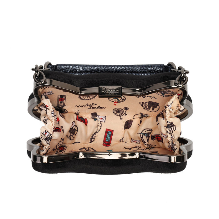 A black velvet clutch purse with a silver-tone metal frame and a beige interior printed with London-themed illustrations including red buses, a red telephone booth, and black cursive text.