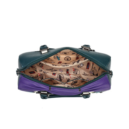 A small structured handbag shown open from the front, with a dark teal exterior, a purple lower section, silver-tone hardware, and a beige patterned interior printed with small illustrated motifs.