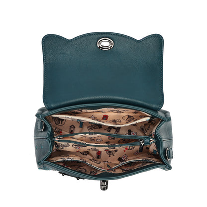 An open teal leather handbag with a cat-ear shaped top, showing a patterned beige interior lining with small illustrated motifs and multiple zip compartments.