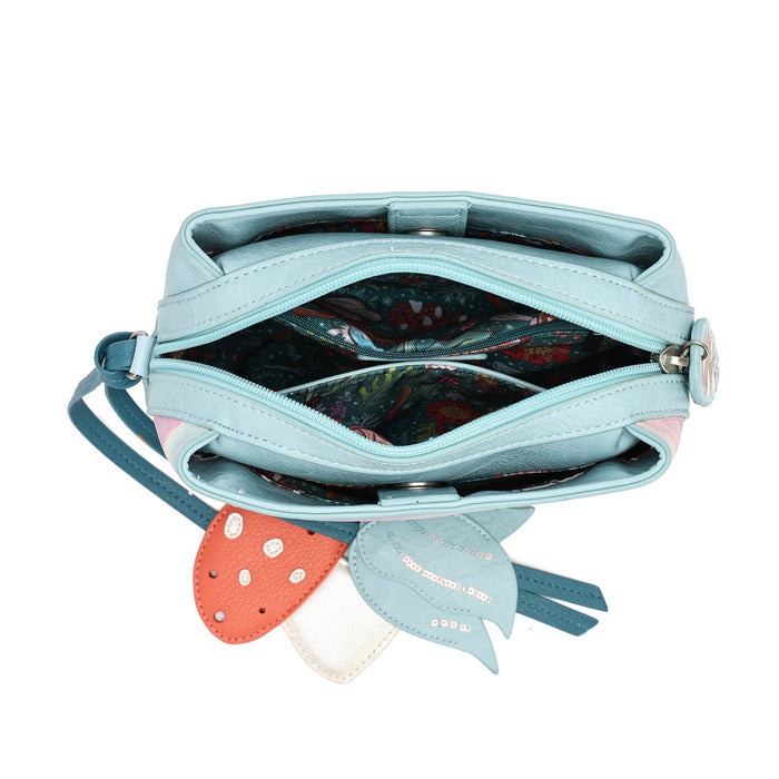 A light blue faux leather shoulder bag shown open from a top-down view, featuring a colorful patterned interior lining and a dangling charm with a strawberry and two small cat-shaped tags.