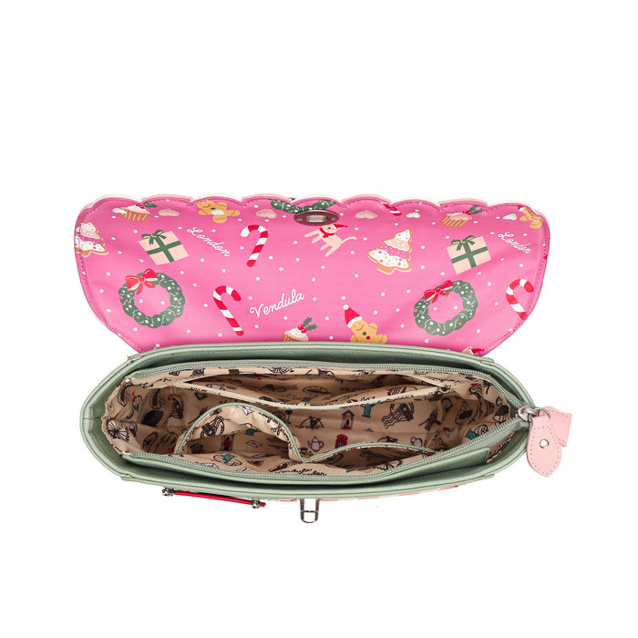 An open pink zippered pouch or organizer shown from above on a white background. The exterior is bright pink with a Christmas print featuring candy canes, green wreaths, Santa, and ornaments.