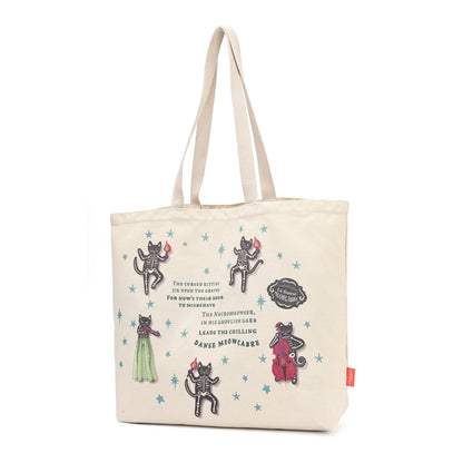 An off-white canvas tote bag with dual shoulder straps, decorated with whimsical cat illustrations, star motifs, and a quote from 'The Chronicles of Narnia' printed on the front.