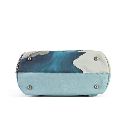 A versatile carryall that can be worn as a backpack, shoulder bag, crossbody or grab tote, with a padded tech section and organised internal storage. Embroidery and appliqué add texture to artwork featuring snowy toadstool houses, fairy doors, winter trees, rabbits and snowflakes.