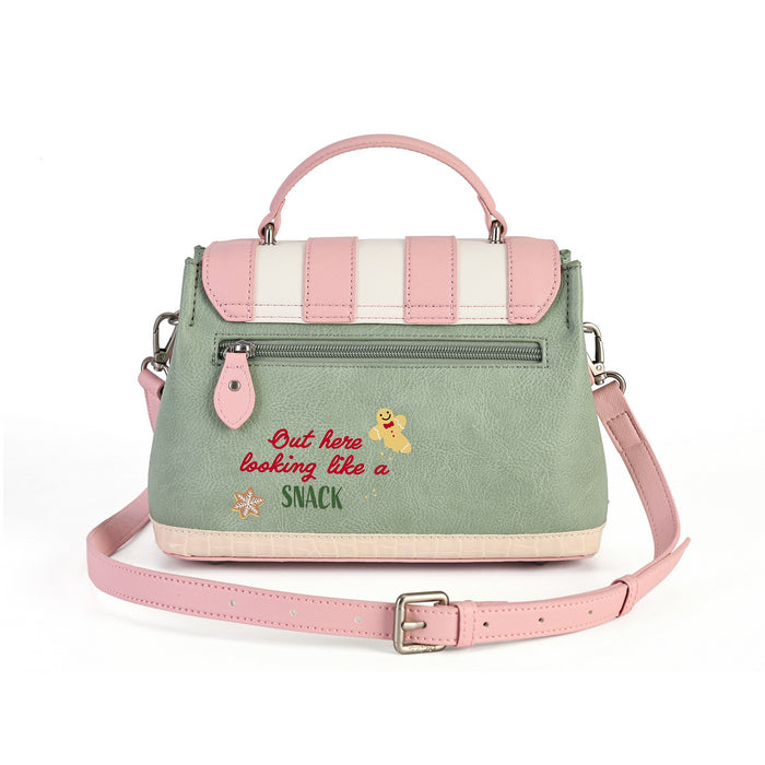 A pastel green and pink handbag with a top handle, a detachable pink shoulder strap, and embroidered text reading 'But here looking like a SNACK' with a small cartoon character on the front.