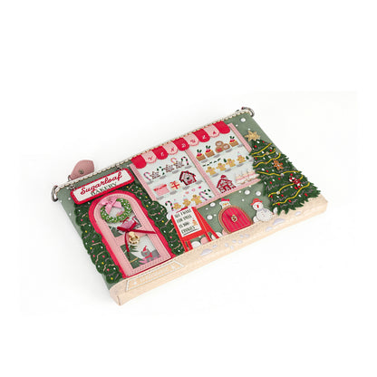A wooden advent calendar toy with a Christmas village theme, featuring colorful felt windows, stockings, a tree, and a sleigh on a white background.