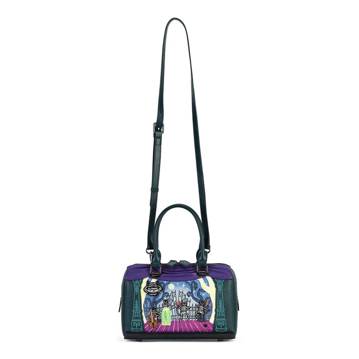 A structured handbag with a purple top panel, dark teal leather sides and shoulder strap, and a colorful illustrated front panel depicting a fantasy scene with a character on a pink carpet.