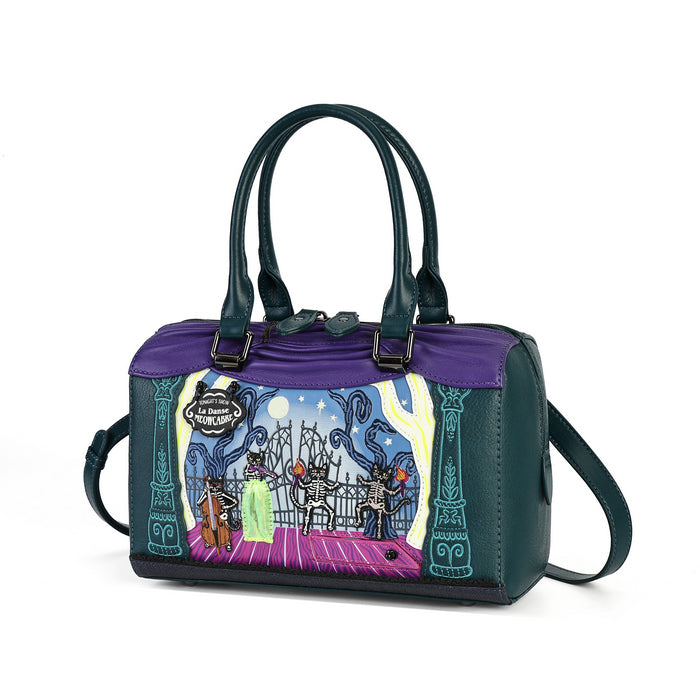A dark green and purple handbag with a colorful illustrated front panel showing a band on stage, photographed on a clean white background.