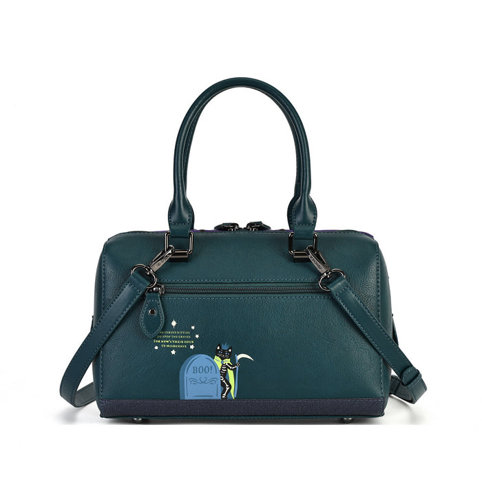 A dark teal leather handbag with a top handle, detachable shoulder strap, and a small cartoon tombstone graphic on the front pocket, shown against a plain white background.