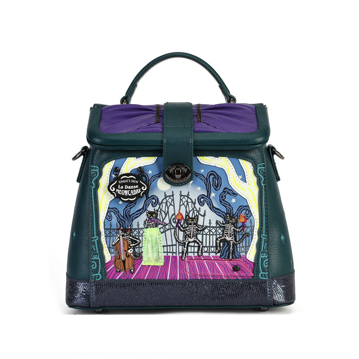 A structured handbag with a dark teal leather exterior, purple top flap lining, and a colorful illustrated front panel depicting skeleton figures under a blue and yellow sky.