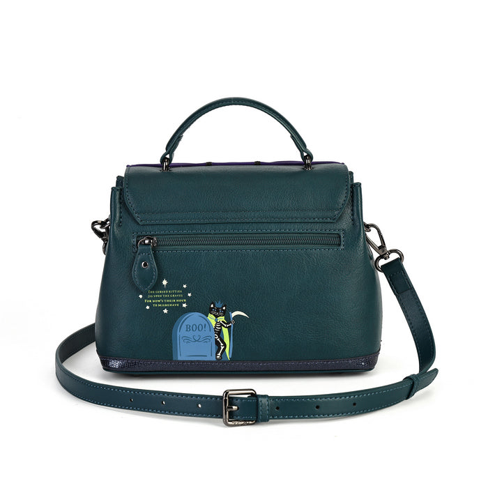 A dark teal leather handbag with a top handle, front zip pocket, and an attached shoulder strap, featuring a small cartoon tombstone graphic on the front.