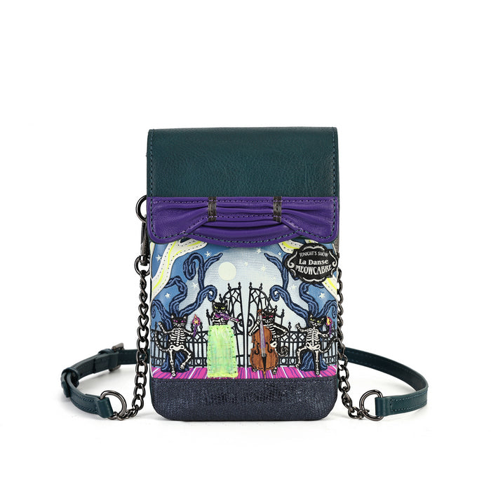 A small crossbody phone bag with a dark teal leather top flap, purple bow detail, and a colorful illustrated front panel showing a graveyard scene. The bag has a dark teal denim-like bottom, a purple strap, and a dark teal shoulder strap with metal rings and chain links, photographed on a white background.