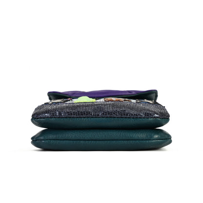 A folded dark teal leather clutch or wallet with a textured black snakeskin pattern panel on the front, set against a plain white background.