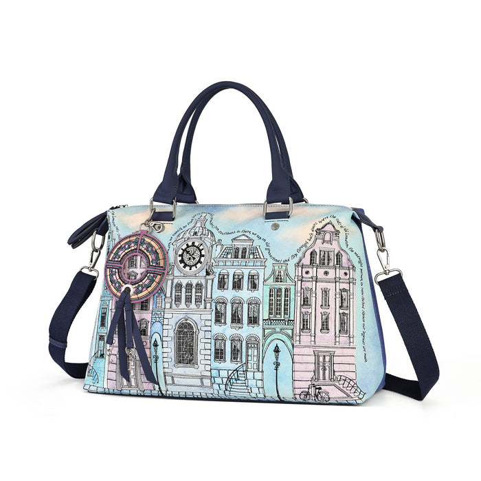 A structured handbag with a light blue and pink watercolor-style illustration of classic European canal houses. The bag features dark navy blue handles, a matching navy blue shoulder strap, silver-tone hardware, and a decorative circular charm hanging from the side.