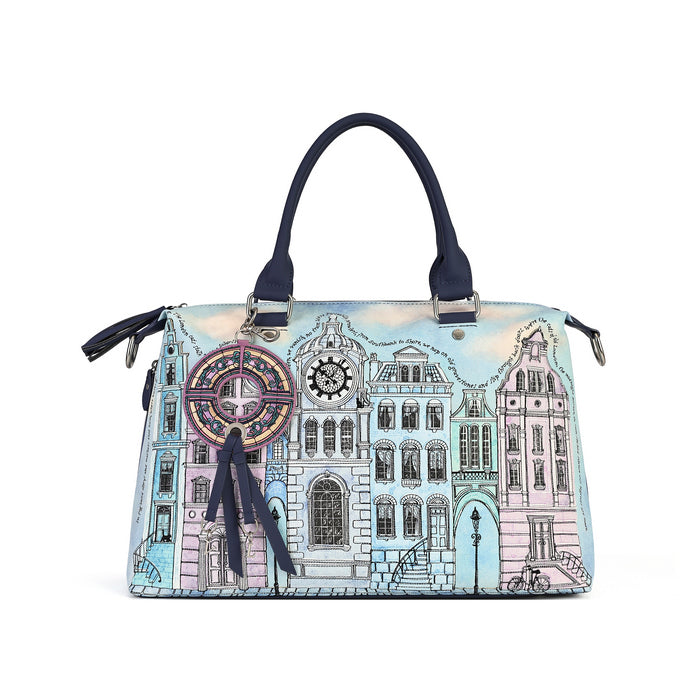 A structured handbag with a light blue background and an illustrated cityscape design in pastel pink, lavender, and black. The bag features dark navy blue handles, a matching navy blue tassel charm, and silver-tone hardware.