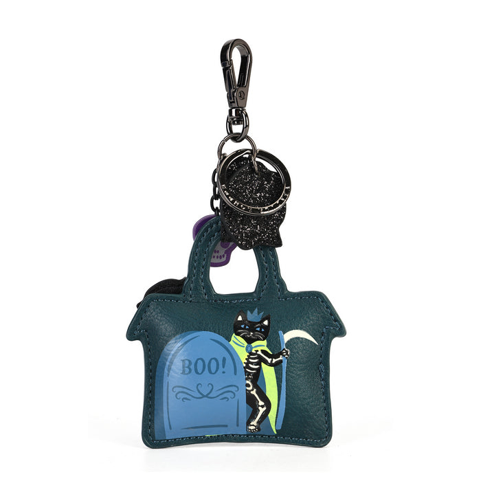 A Halloween-themed keychain bag shaped like a small haunted house, featuring a blue tombstone with 'BOO!' and a black cat skeleton holding a lantern. The bag is dark teal with a black glittery clasp and keychain attachment on a white background.