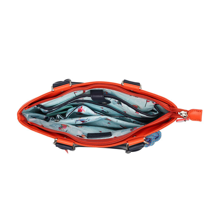An open bright orange bag with a light blue and red patterned interior lining, photographed on a plain white background.