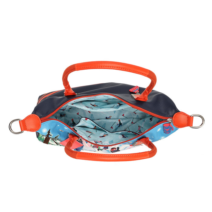 An open navy blue handbag with bright orange handles and trim, showing a light blue patterned interior lining, photographed on a plain white background.