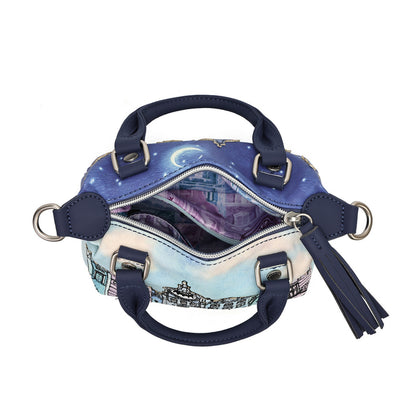 An open satchel handbag with navy blue leather handles and trim, featuring a printed celestial night sky design in blue, purple, and white on the exterior, with a tassel charm and silver-tone hardware on a plain white background.