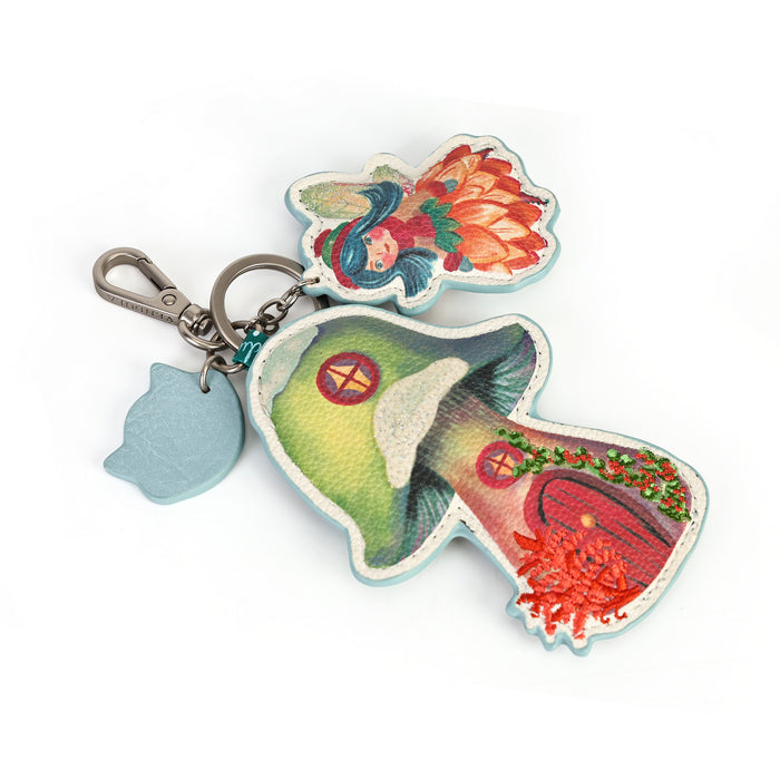 A small decorative charm made for attaching to keys or bags. Printed and embossed vegan leather features snowy toadstool houses, fairy doors, winter trees, rabbits and snowflakes, finished with a secure clip and split ring.