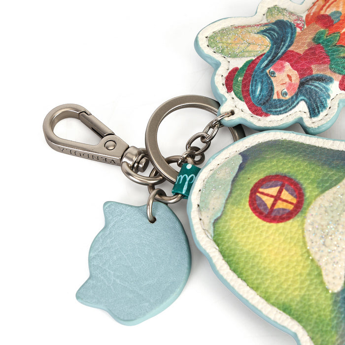 A small decorative charm made for attaching to keys or bags. Printed and embossed vegan leather features snowy toadstool houses, fairy doors, winter trees, rabbits and snowflakes, finished with a secure clip and split ring.